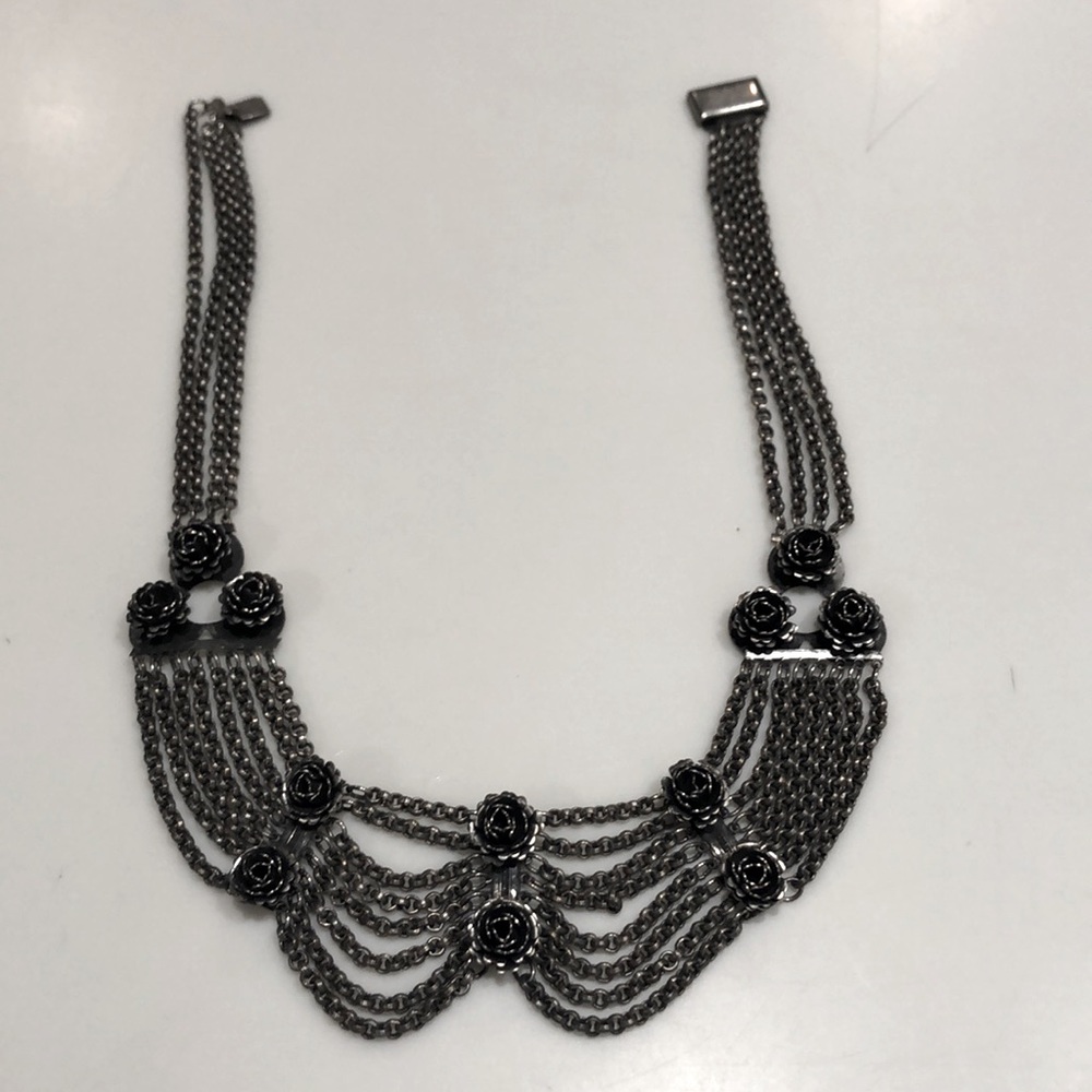 A silver necklace with roses.